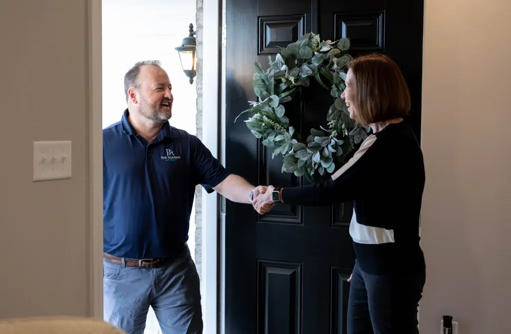 Technician shaking hands with customer in front entryway in Knoxville, TN.