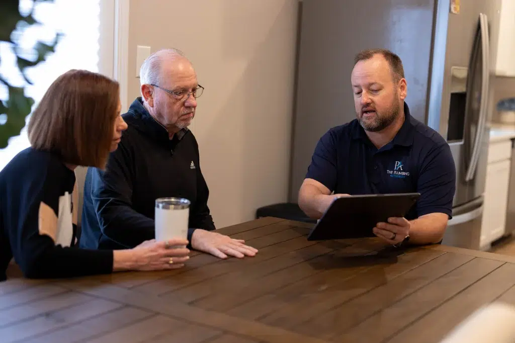 Technician showing customer options at kitchen table in Knoxville, TN.