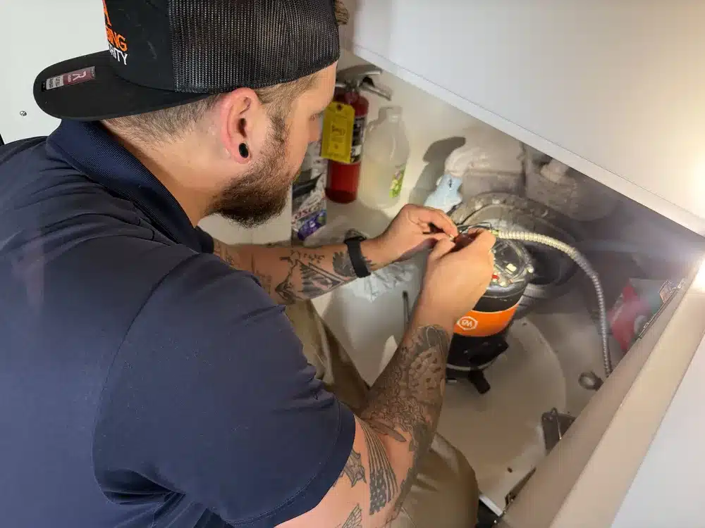 tech working on garbage disposal