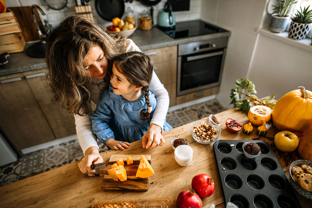 mother and daughter prepping food for Thanksgiving meal