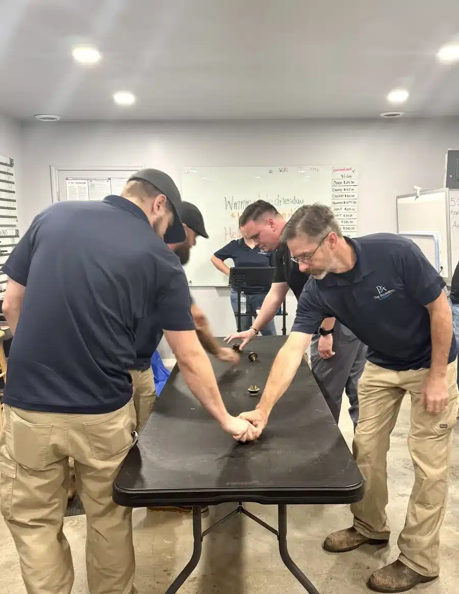 Crew gathered around tables participating in a group challenge on Winning Wednesday