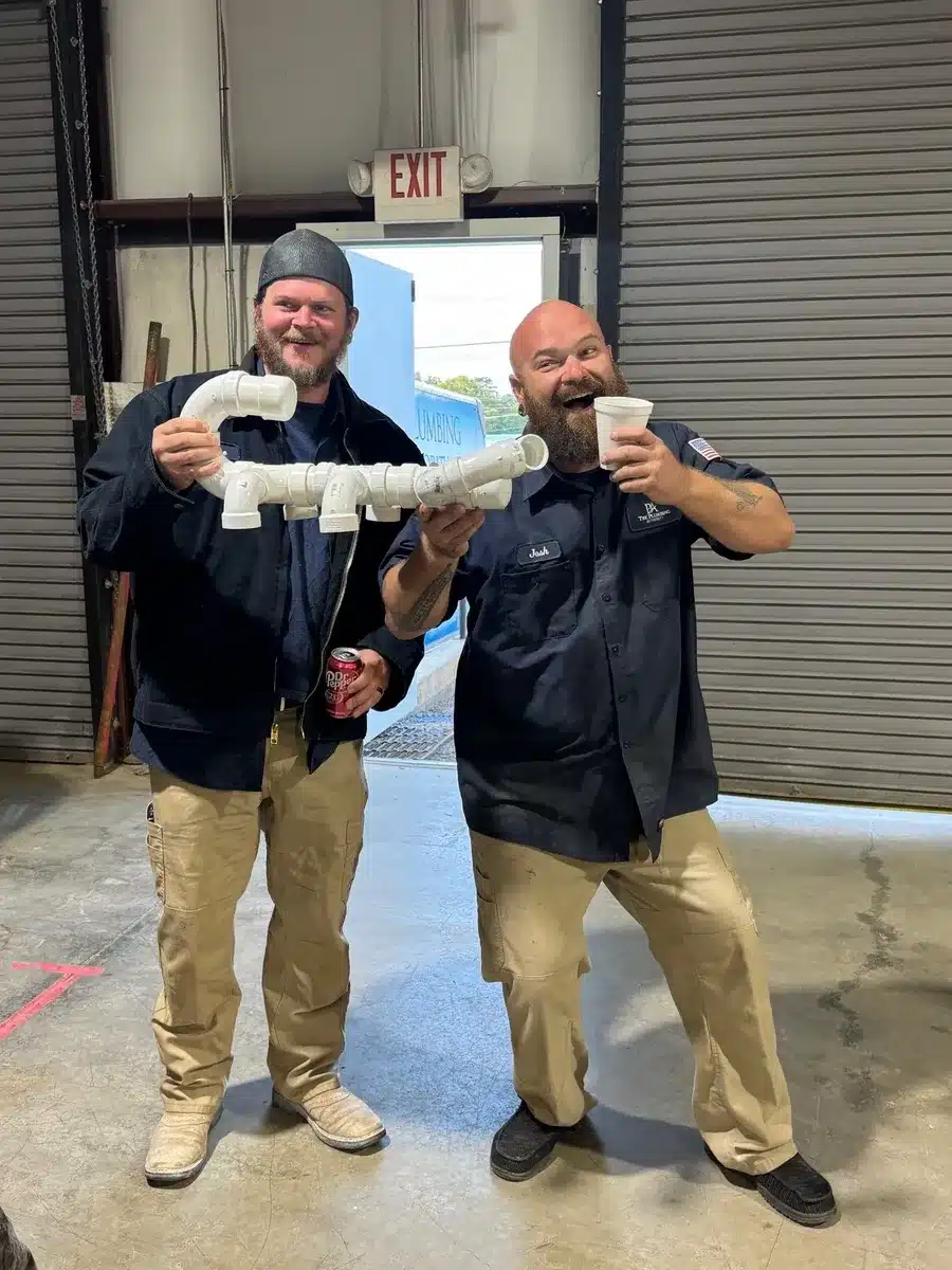 Employees holding up their completed project and celebrating a Winning Wednesday win