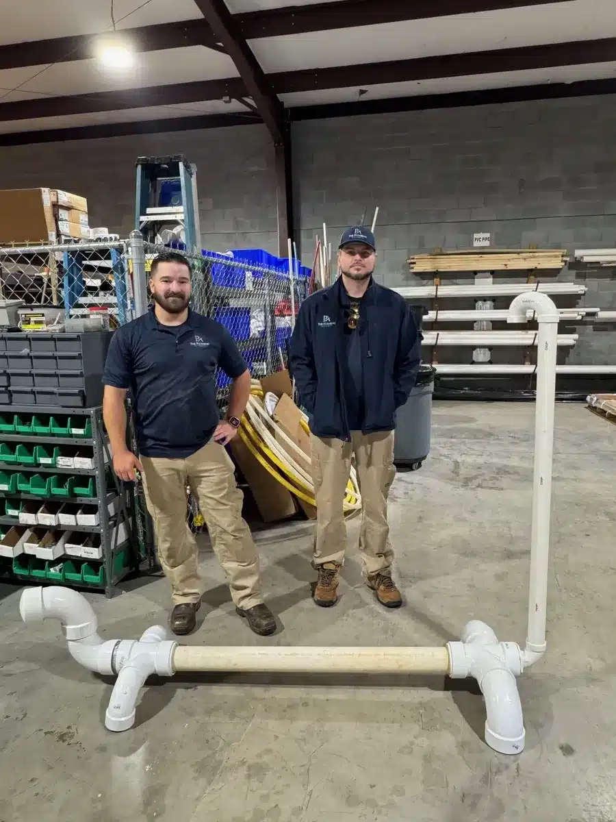 Crew posing with their completed pipe-building project during Winning Wednesday at the shop