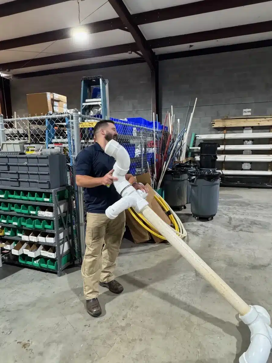 Team member carrying a long PVC pipe during a Winning Wednesday challenge