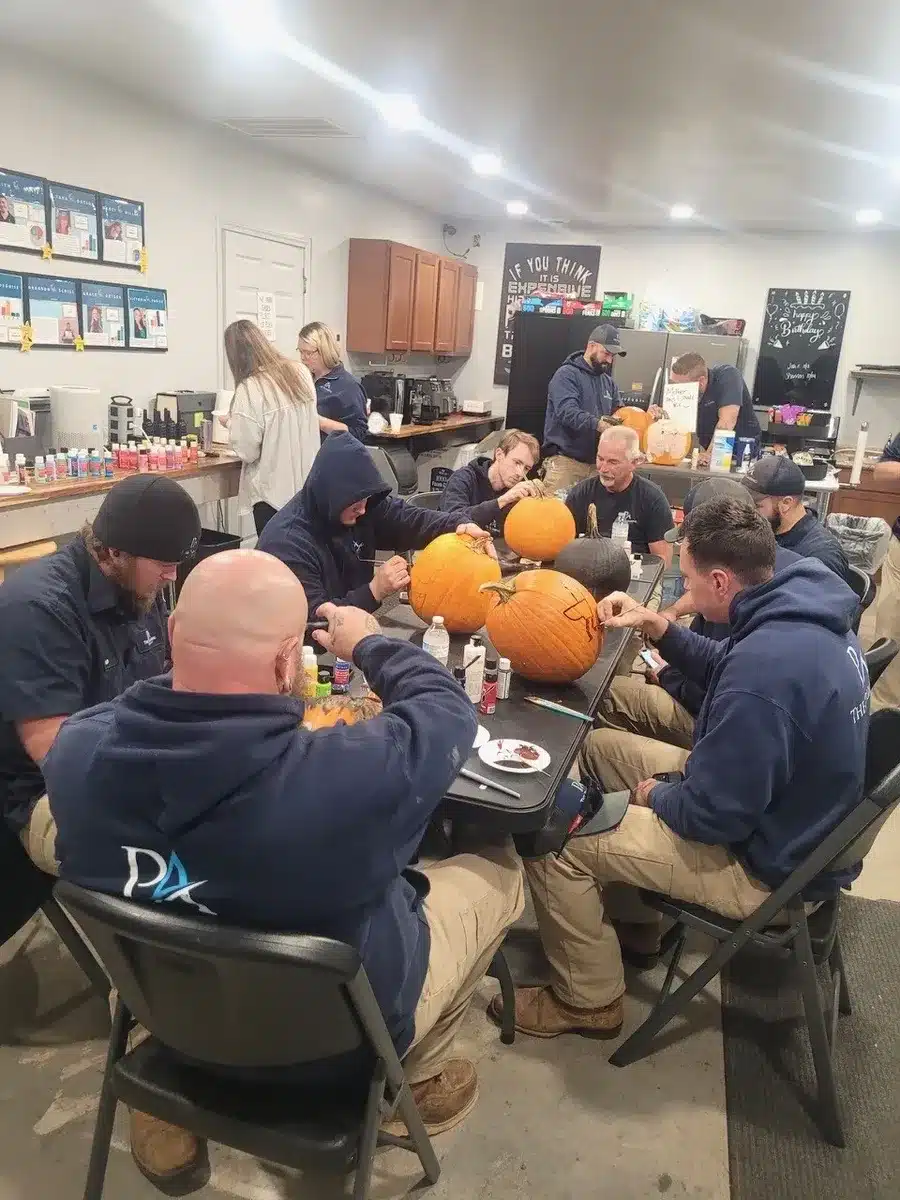 Team carving pumpkins together during a Winning Wednesday event at The Plumbing Authority